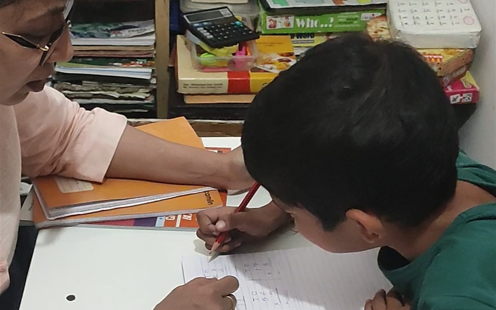 A special educator helping an older student with math work at ArambH Autism Centre