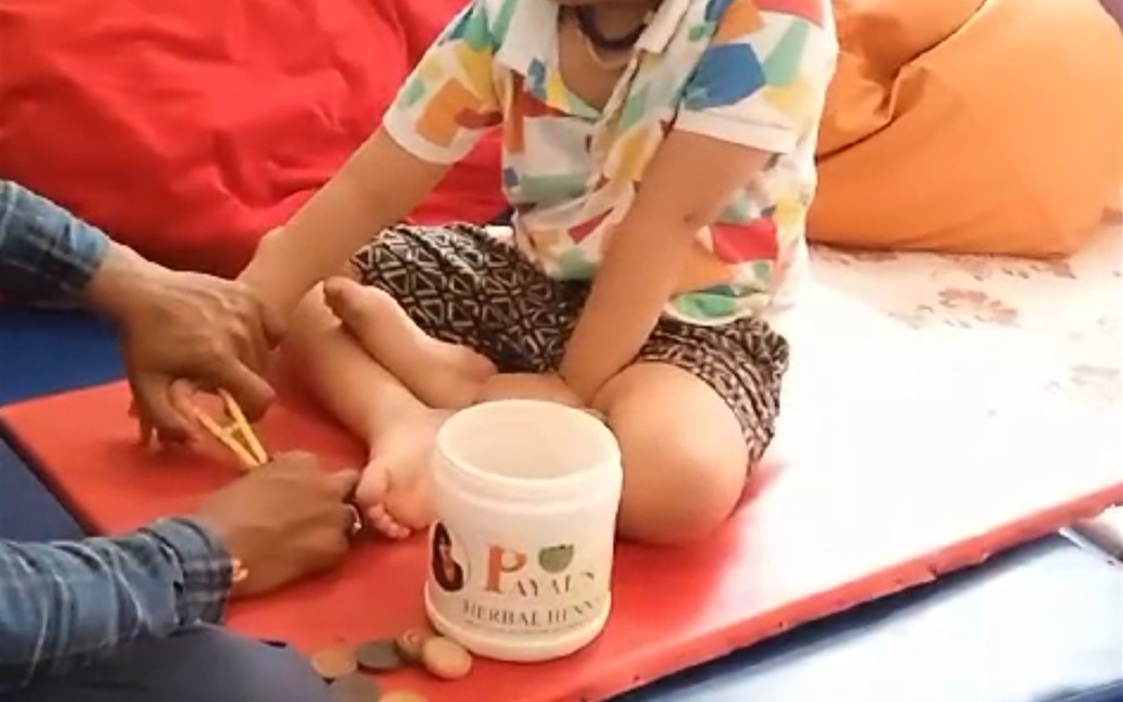 Young boy doing a coin sorting sensory activity on a soft mat