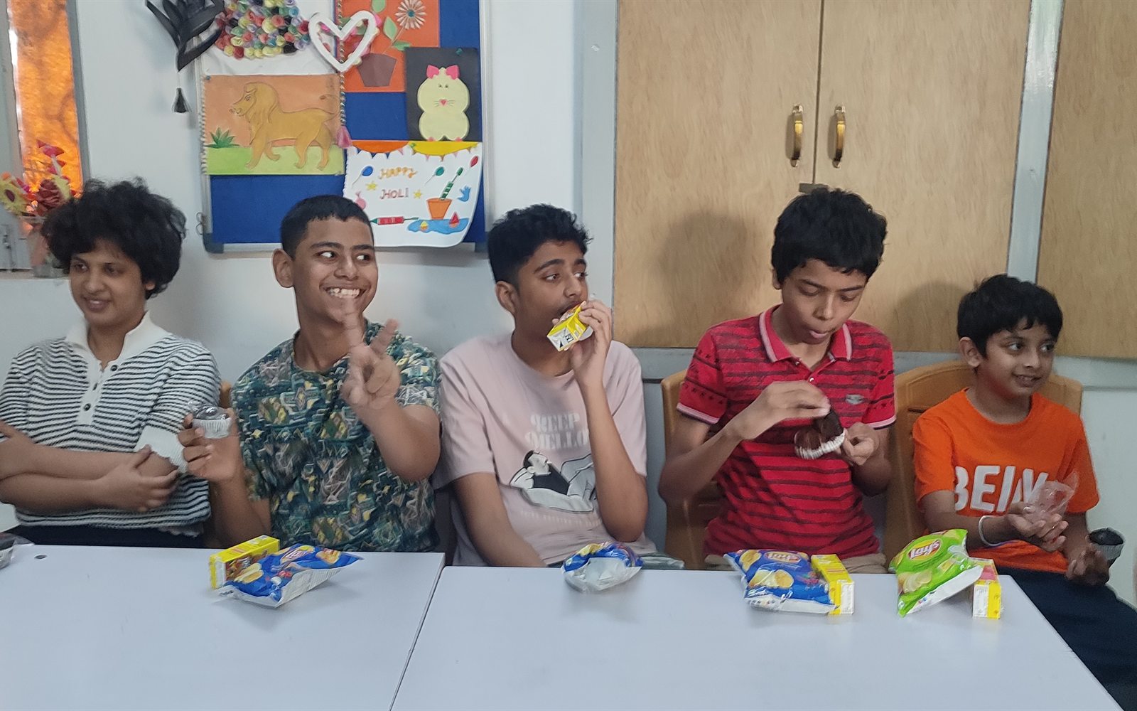 Pre-teen students enjoying snacks together during a social activity at ArambH